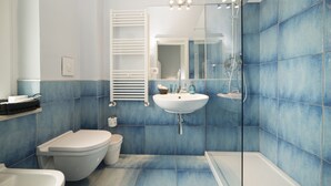 A bathroom with a white toilet, a sink, and a shower. - CAPRI B&B (Salerno)
