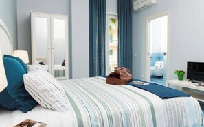 A hotel room with a bed, a desk, a TV, a wardrobe, and a bathroom visible through an open door. - CAPRI B&B (Salerno)