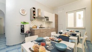 A modern kitchen with a dining area, a microwave, and a window. - CAPRI B&B (Salerno)