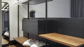 Une cuisine moderne dotée d’un plan de travail en bois, de meubles de rangement noirs et d’un four encastré.