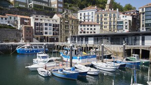 Un puerto deportivo con barcos amarrados, rodeado de edificios con balcones y terrazas.