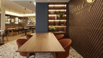 A modern hotel lobby with a wooden reception desk, orange chairs, a bar area, and a patterned wall with the hotel name.