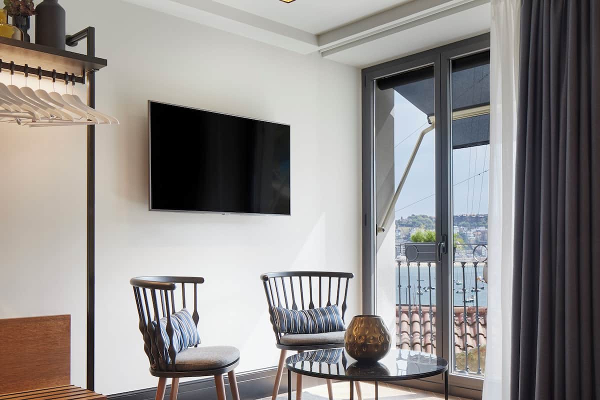 Junior Suite SANSEbay | Area soggiorno | Smart TV, libri