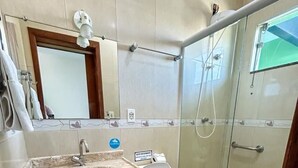 Une salle de bain avec un lavabo en marbre, des toilettes, une douche en verre et une serviette sur le sol.