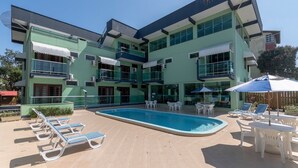 Un immeuble à plusieurs étages doté d’une piscine, d’un espace extérieur aménagé et de balcons.