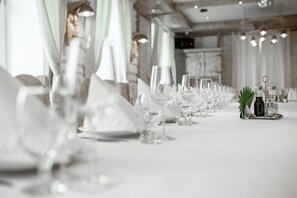 Ein langer Tisch gedeckt mit mehreren Weingläsern und Tellern, was auf eine festliche Mahlzeit hindeutet.