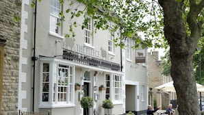 A traditional pub named "The Fleece" with outdoor seating and potted plants. - The Fleece (Witney)
