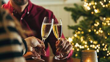 A person holding two champagne glasses.