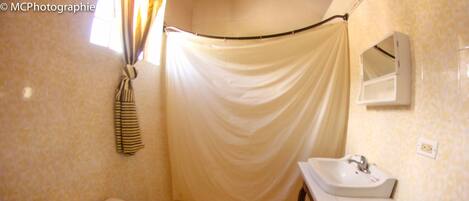 A bathroom with a toilet, a sink, and a shower curtain.
