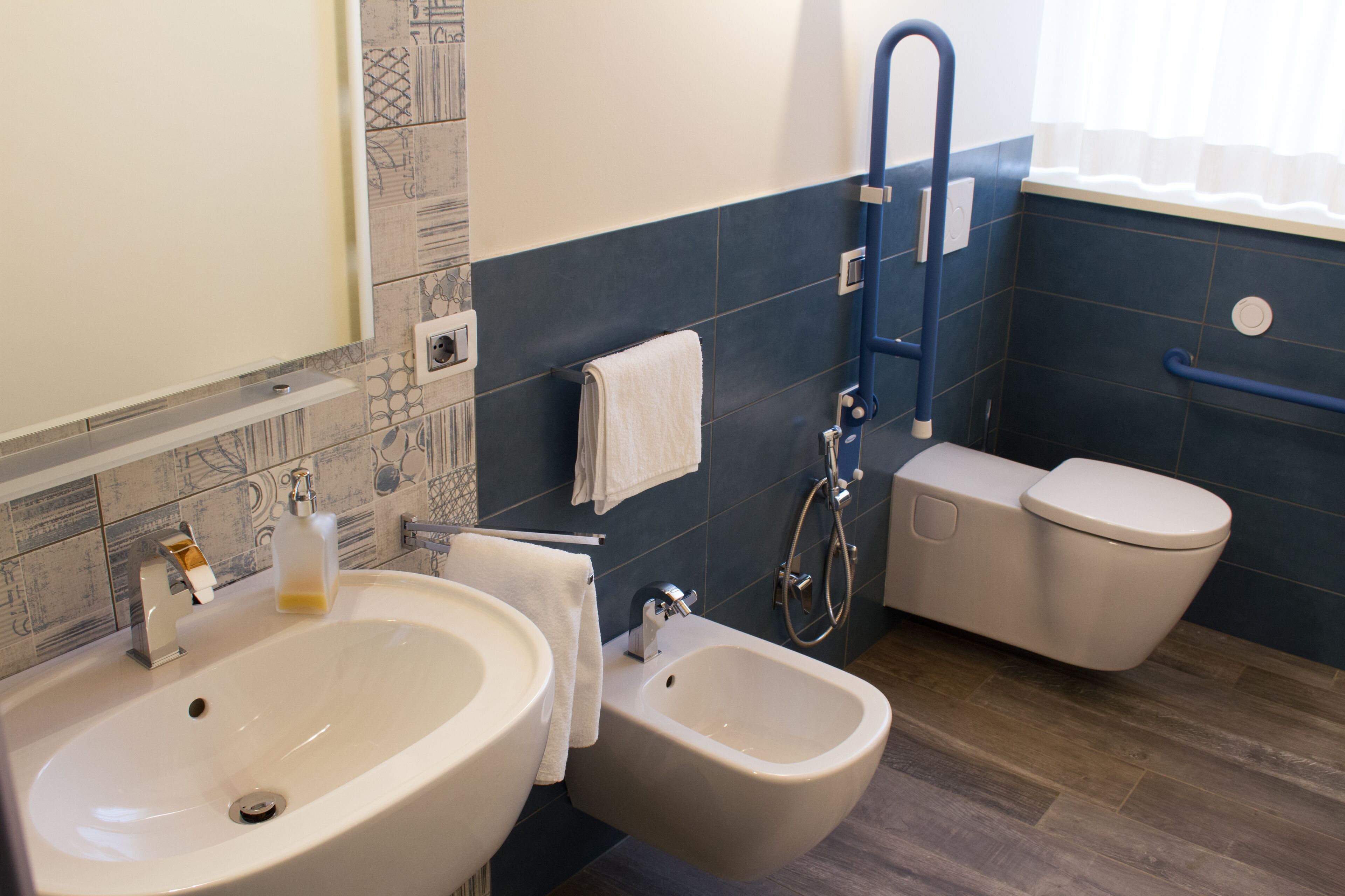 Une salle de bain avec un grand lavabo, un bidet et des toilettes.