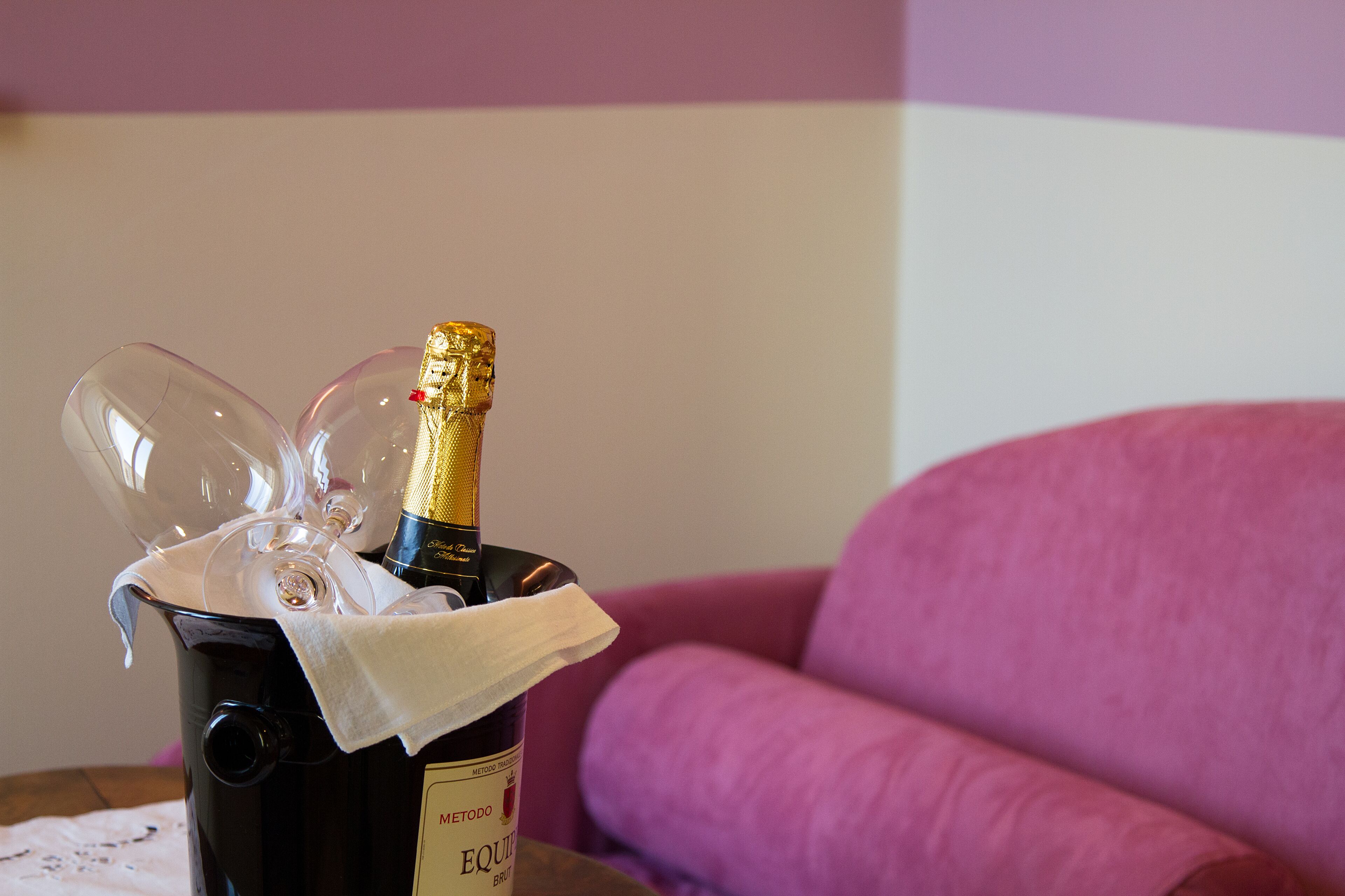 Una botella de Metaxa Equinox, copas y una servilleta de tela sobre una mesa.