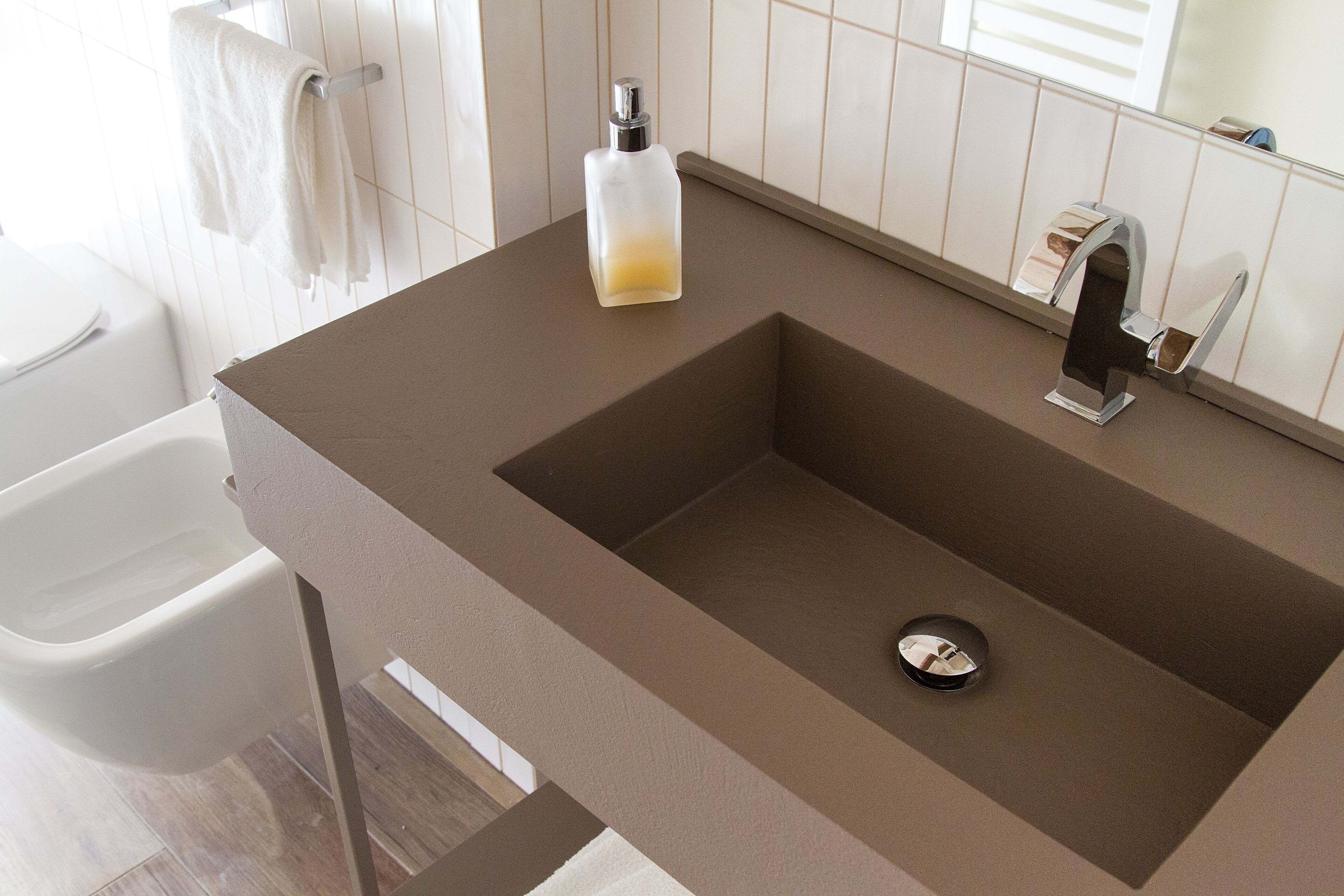 Une salle de bain avec un lavabo moderne, des toilettes et un miroir.