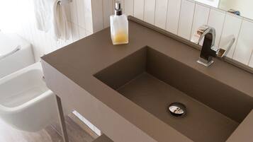 Une salle de bain avec un lavabo moderne, des toilettes et un miroir.