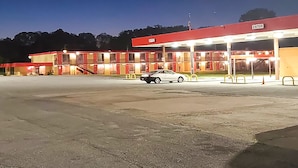 Une station-service avec plusieurs pompes et une voiture garée devant.