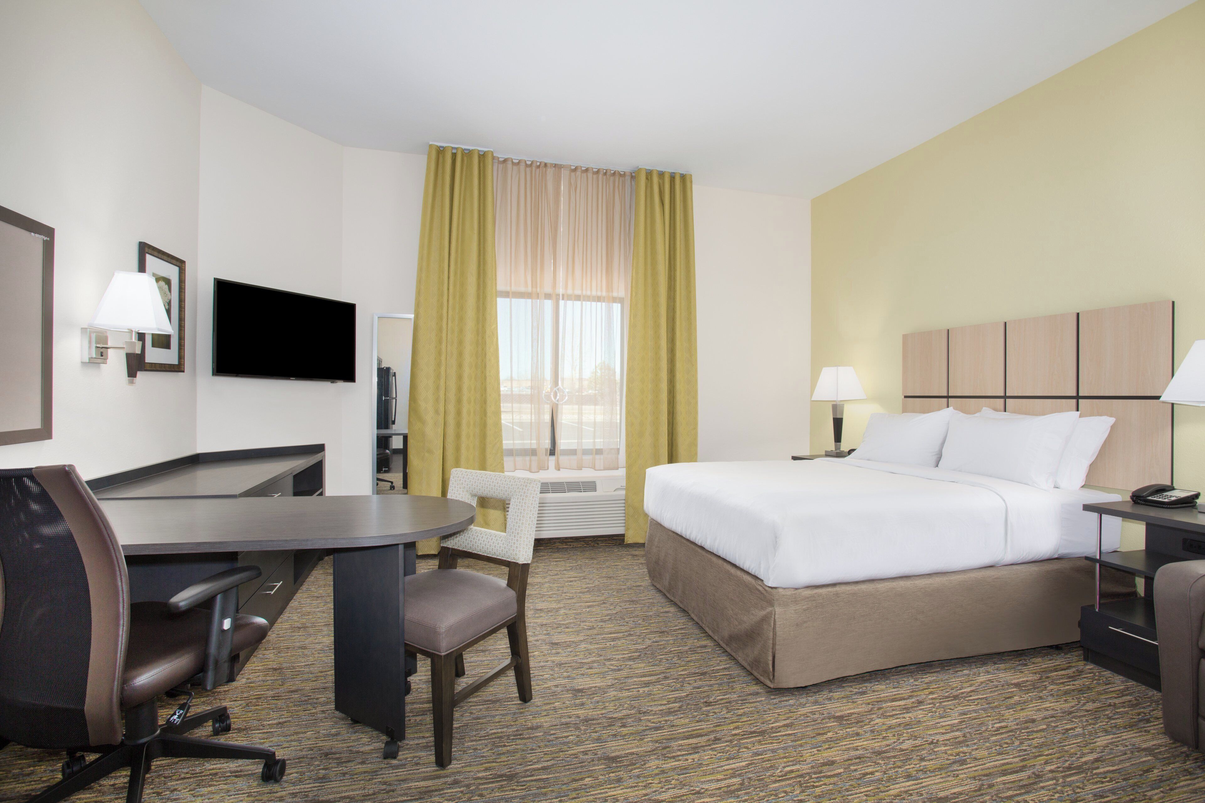 Une chambre d’hôtel équipée d’un lit, d’un bureau, d’une chaise et d’un téléviseur.