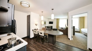 Een moderne hotelkamer met kitchenette, een eethoek en een zithoek.