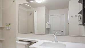 Een moderne badkamer met een wit wastafel, een spiegel en een toilet.