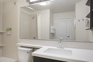 Un baño moderno con un lavabo blanco, un espejo y un inodoro.
