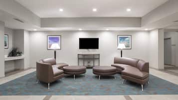 Una sala de estar moderna con un televisor de pantalla plana, dos sofás y una mesa de centro.