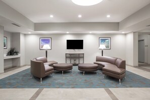 A modern living room with a flat-screen TV, two sofas, and a coffee table.