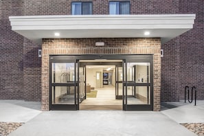 A building entrance with a brick facade, double doors, and a flat roof. - Candlewood Suites Pueblo by IHG (Pueblo)