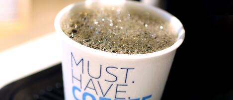 Une tasse à café blanche sur laquelle est inscrit le texte « MUST HAVE COFFEE EXPRESS ».
