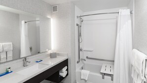 Une salle de bain moderne avec un grand miroir, deux lavabos, une baignoire et une douche.