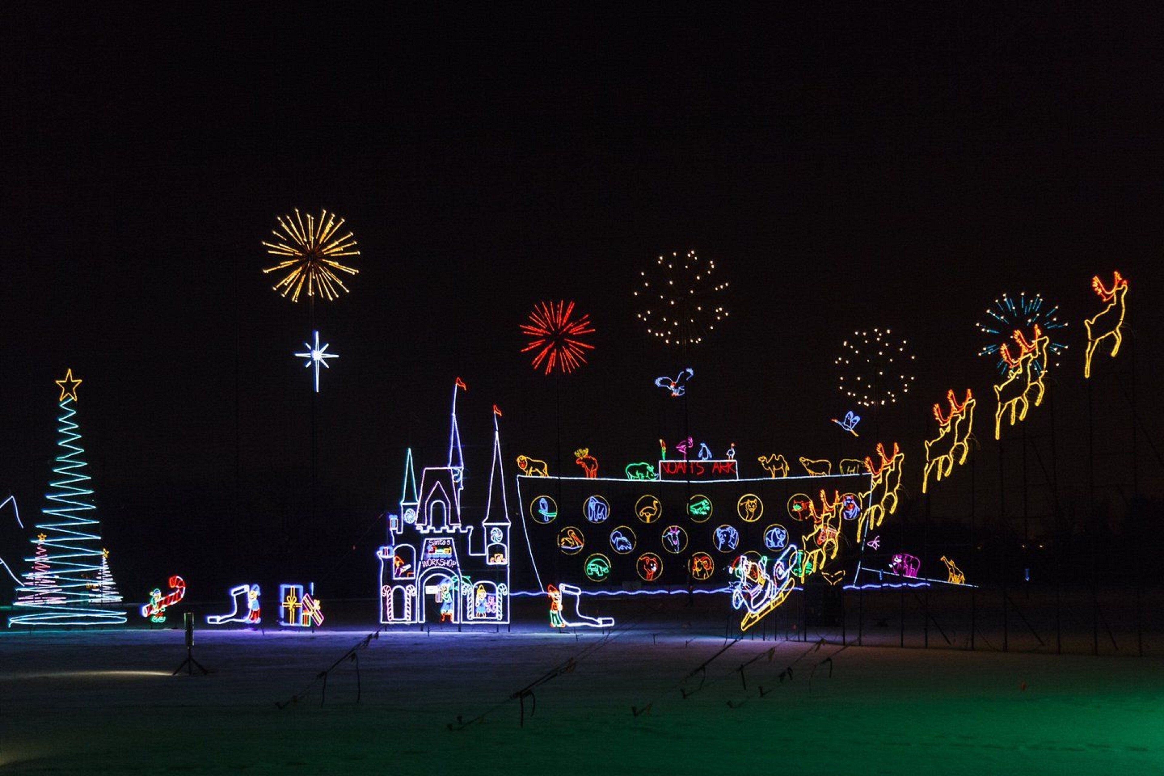 A nighttime outdoor display with illuminated structures and animal figures.