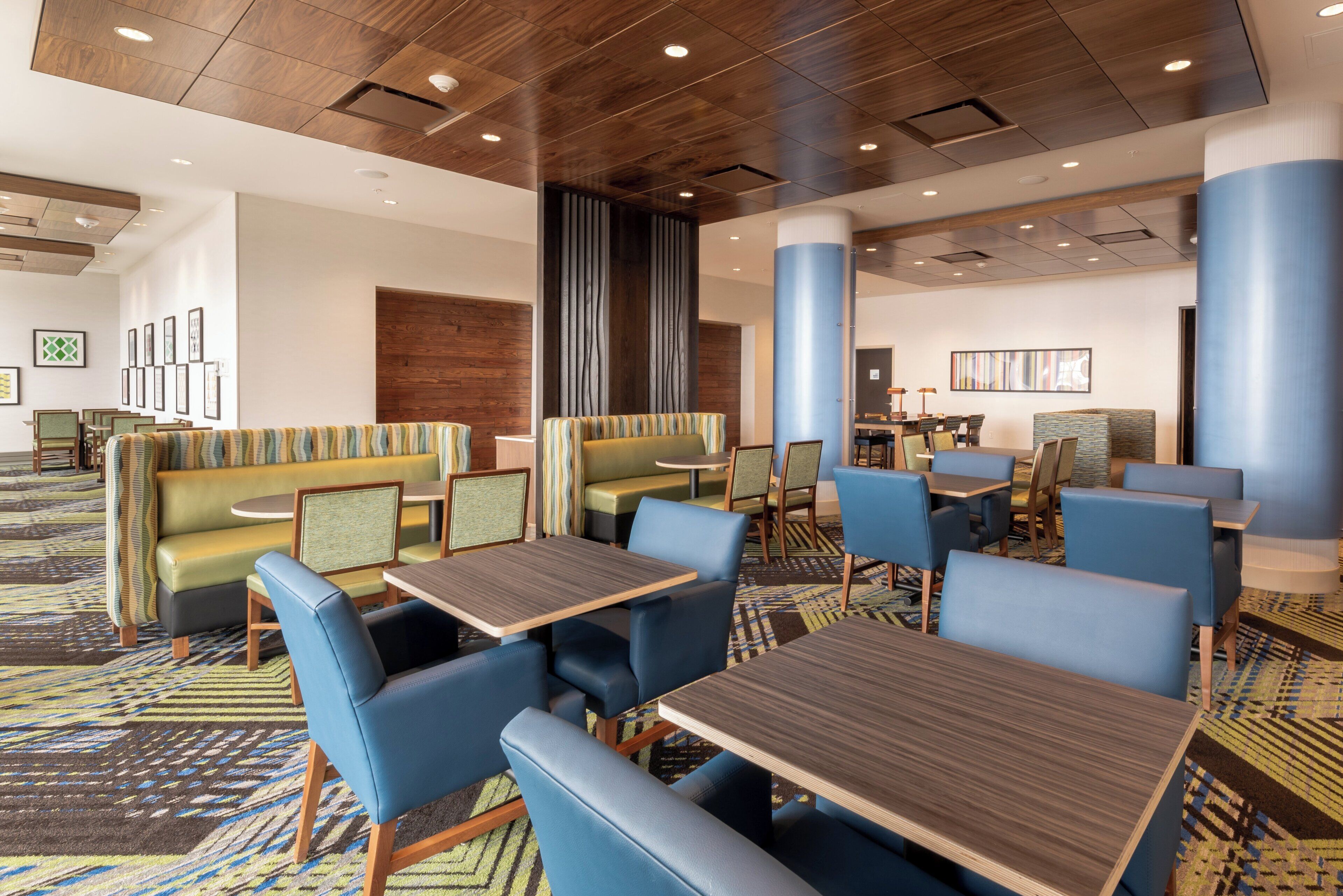 A hotel lobby with seating areas, tables, and a patterned carpet.