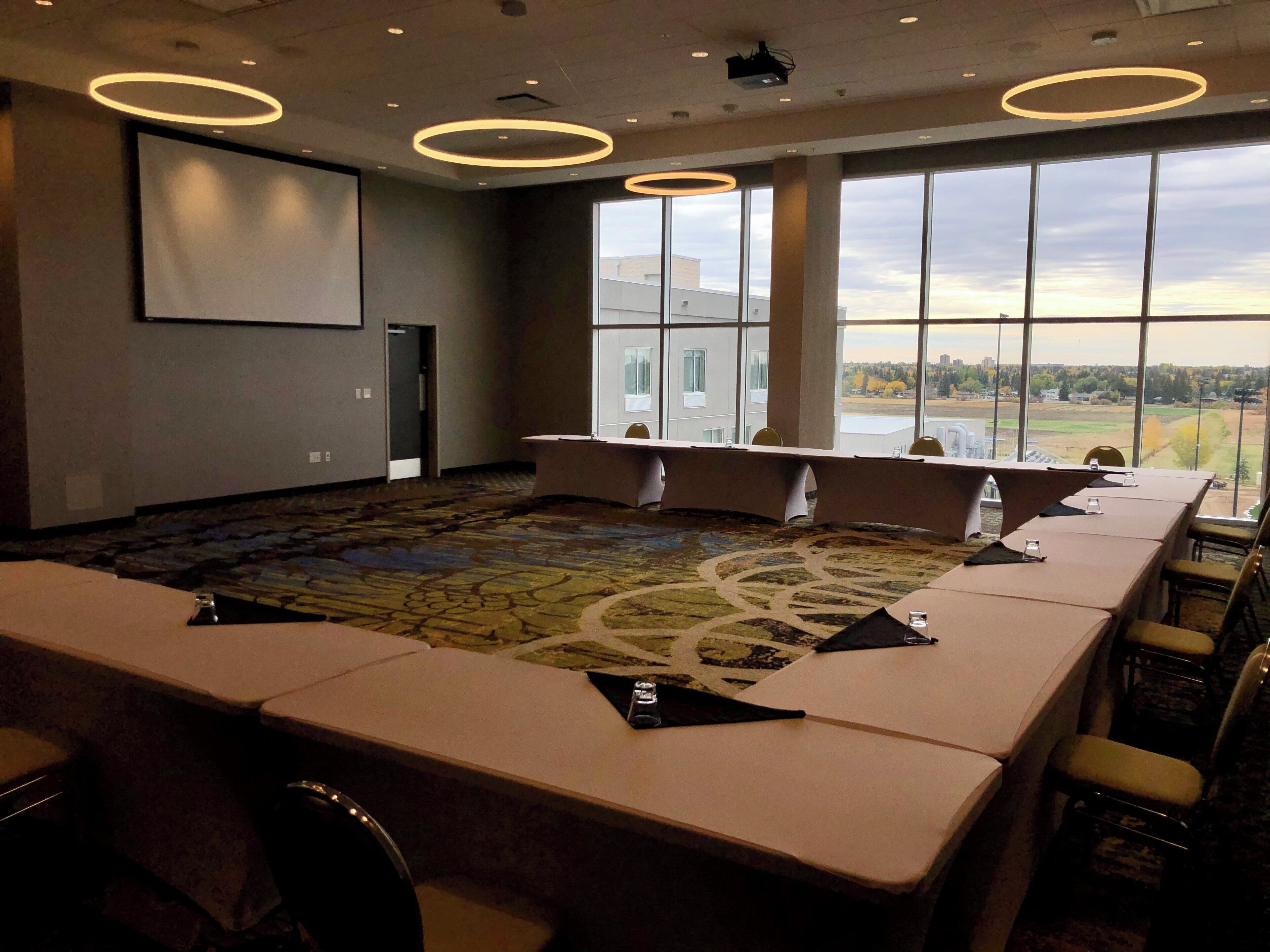 Une salle de conférence dotée d’une grande table, de chaises et d’un sol recouvert de moquette.