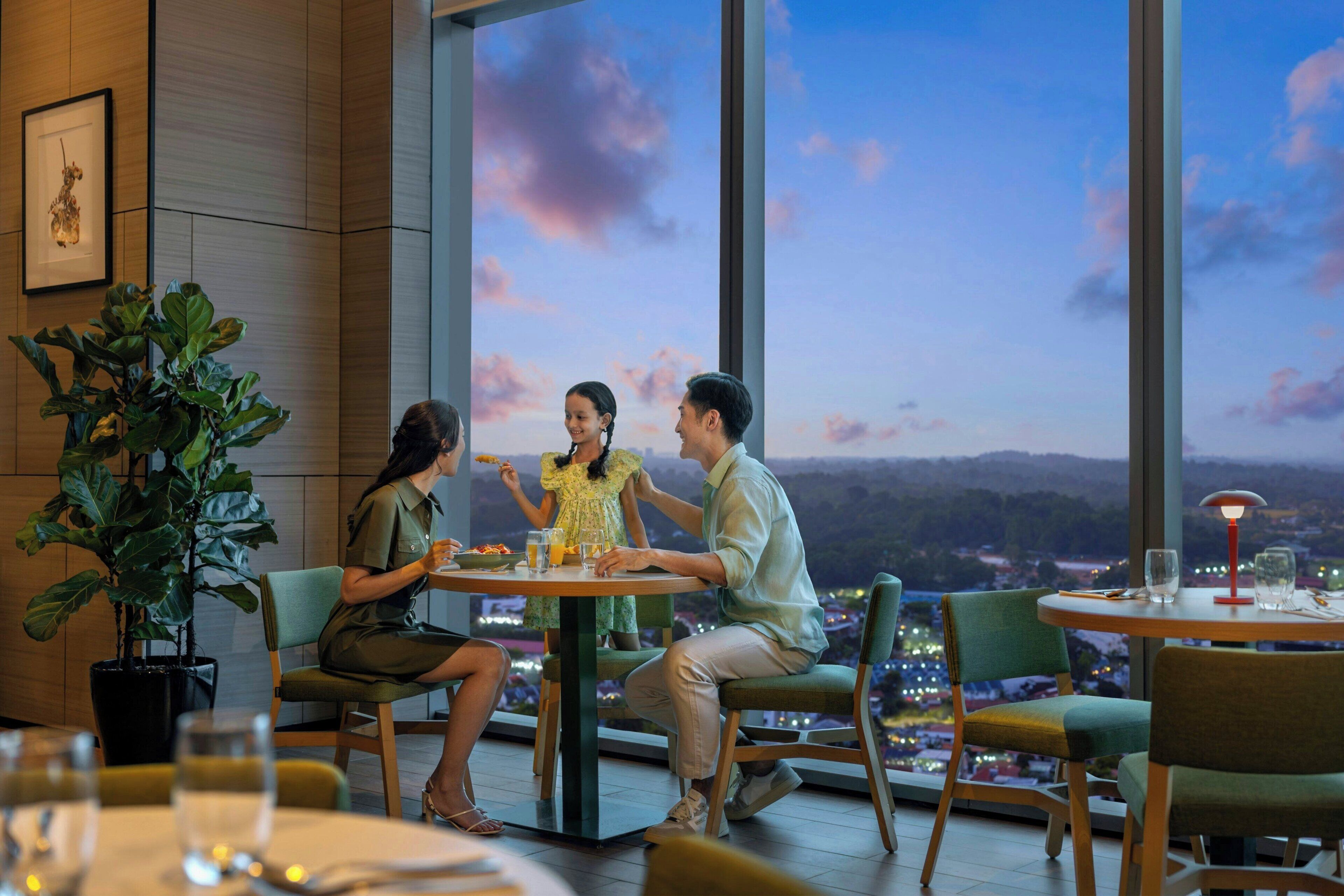 A dining area with a table, chairs, and a large window with a view of the cityscape.