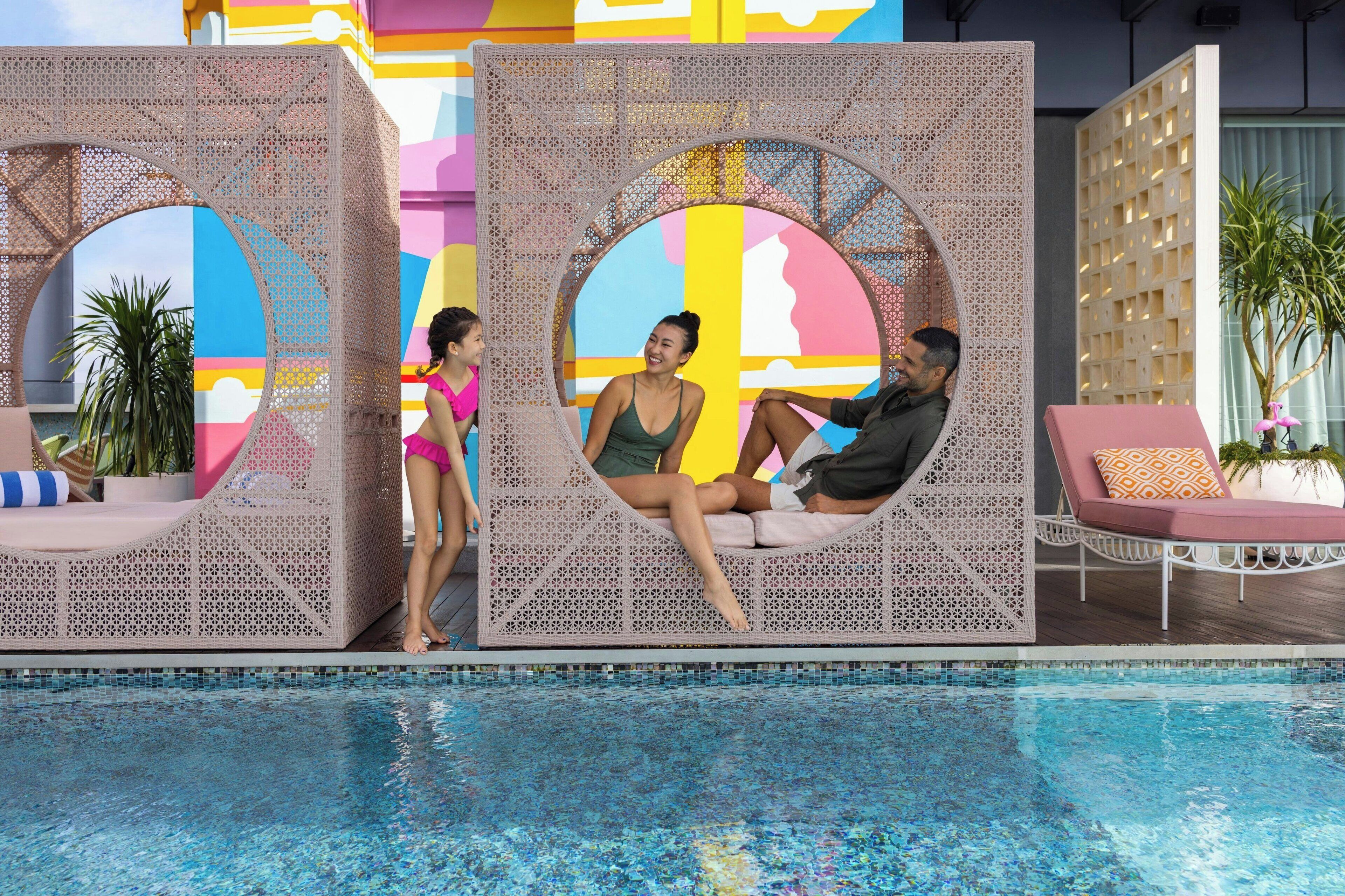 Ein Poolbereich mit Zierzaun, Liegestühlen und freiem Blick auf den Pool.