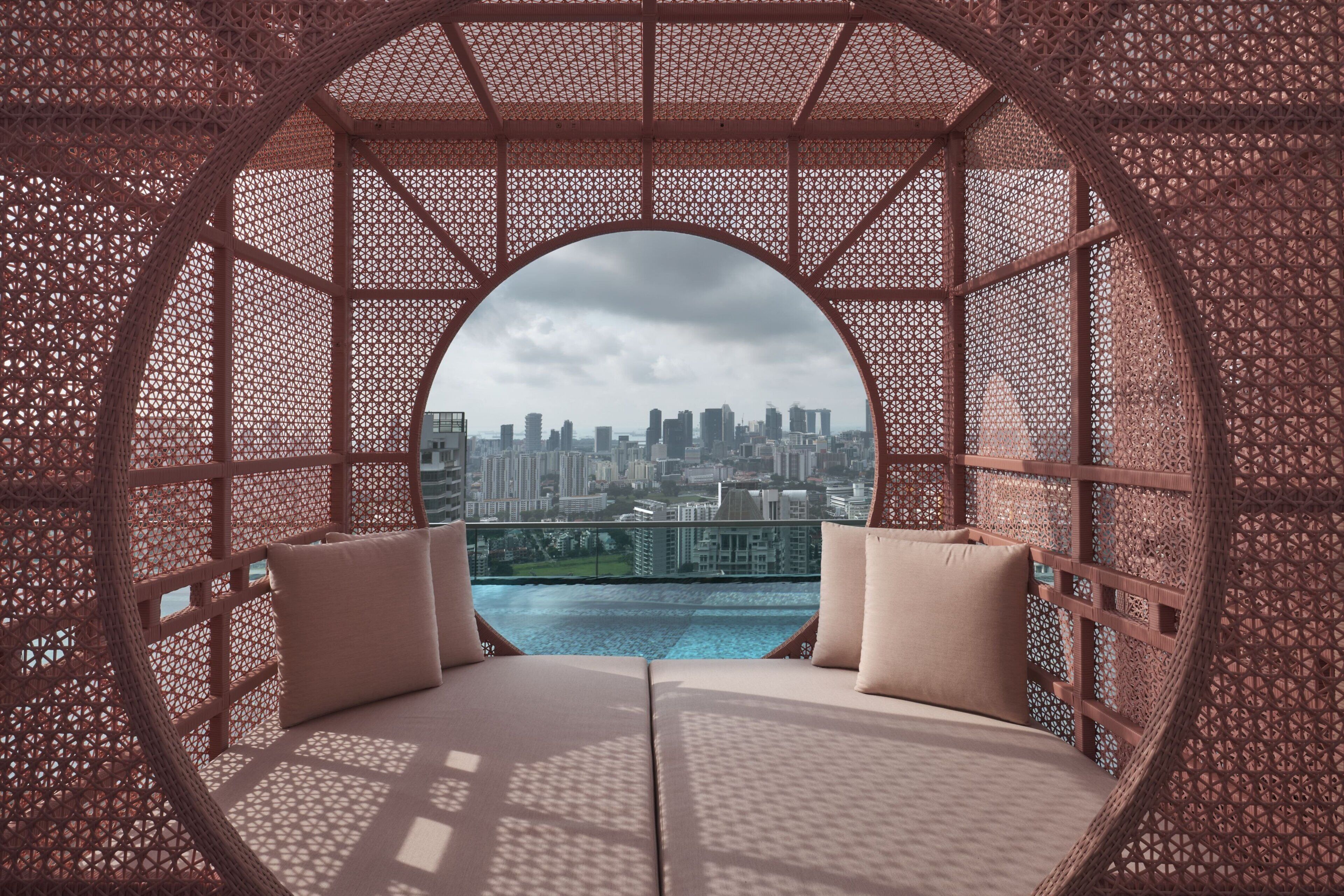 A circular room with a view of a cityscape through a lattice window.