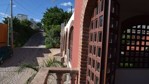 A building with a red brick facade, arched windows, and a paved street leading up to it. - Casa Palmas (Guanajuato)
