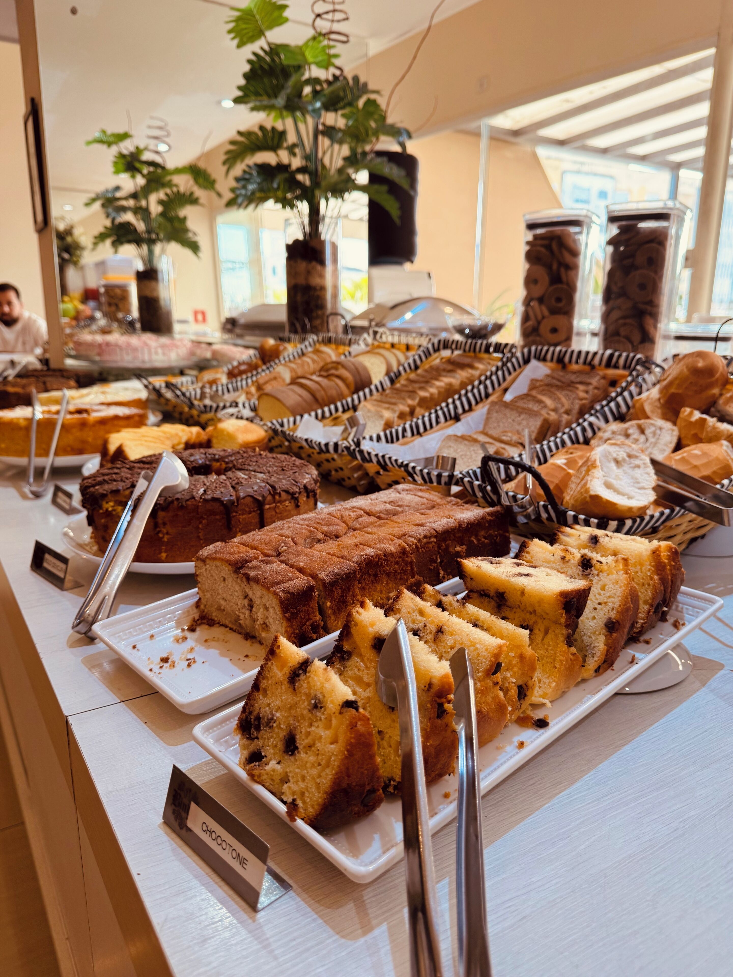 A buffet with various baked goods, including cakes and pastries, displayed on trays.