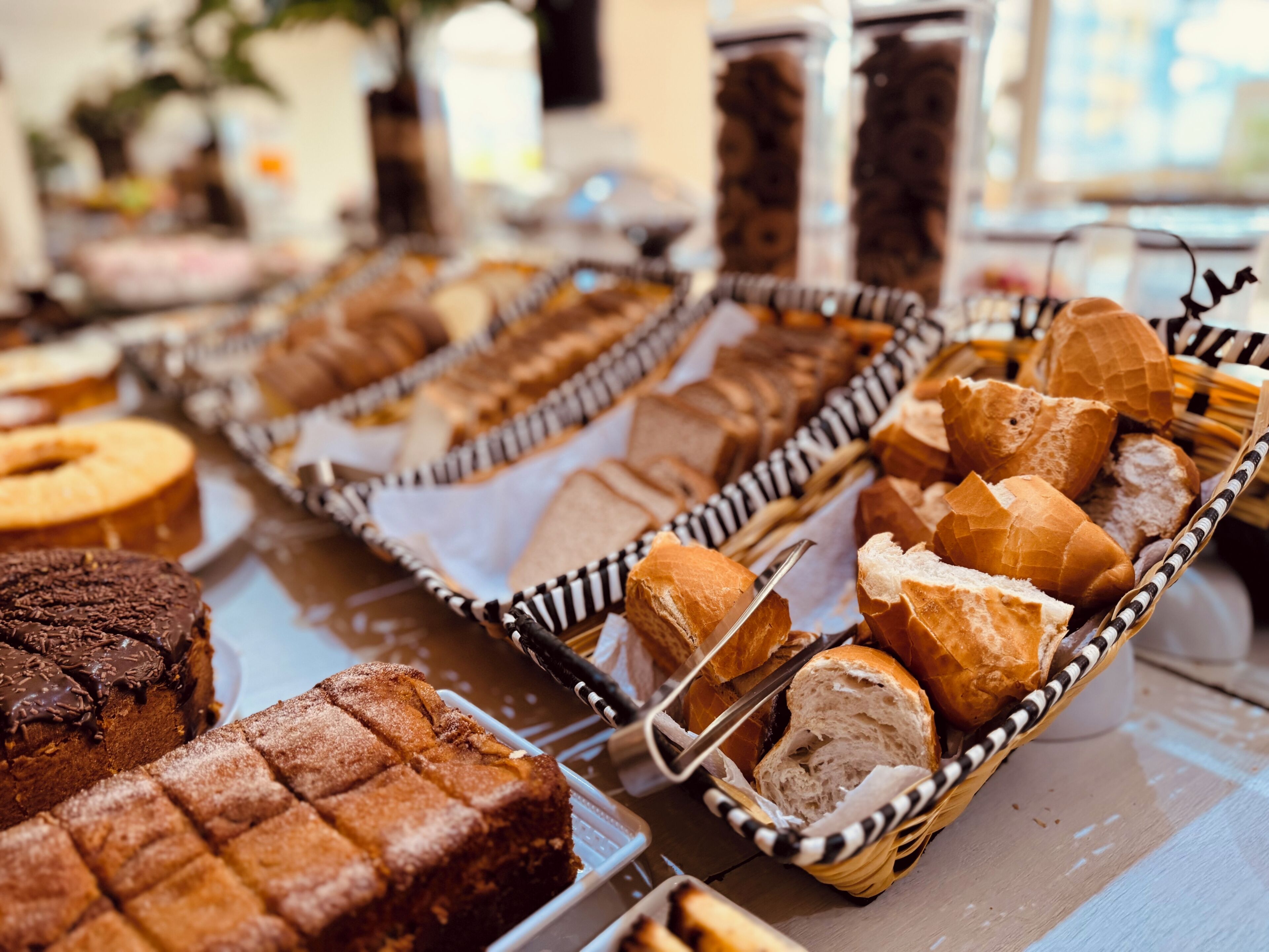 A buffet with various baked goods including bread and cakes.
