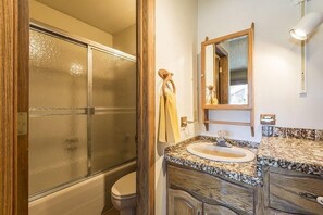 A bathroom with a glass shower enclosure, a wooden vanity with a sink, and a mirror above the vanity. - Phoenix 118 4 Bedroom Townhouse by RedAwning (Steamboat Springs)