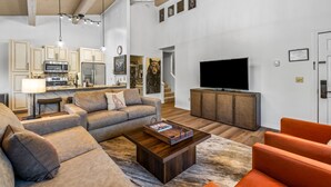 Un salon moderne avec un canapé, une table basse et un téléviseur.