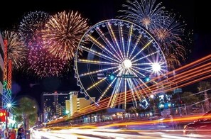 A Ferris wheel with a sign that reads "Joe's White House" and fireworks in the background. - Tilghman Lakes B3 by RedAwning (North Myrtle Beach)