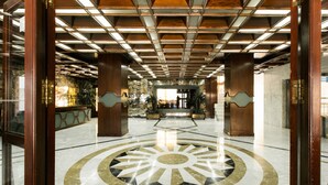 A lobby with a central circular floor design, wooden pillars, and a ceiling with a grid pattern. - Beachfront Condo in Marbella Center with 2 Pools & Parking (Marbella)