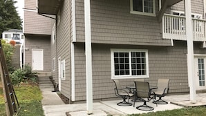 A two-story house with a covered porch and a small outdoor seating area. - Private MIL Apartment in Serene Pacific Northwest Setting (Kenmore)