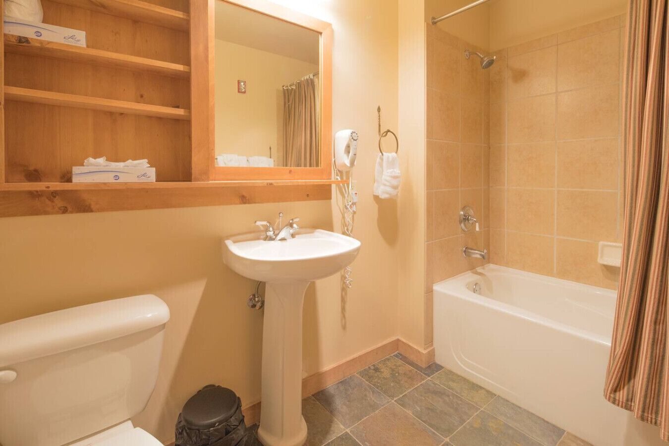 A bathroom with a toilet, sink, and bathtub.