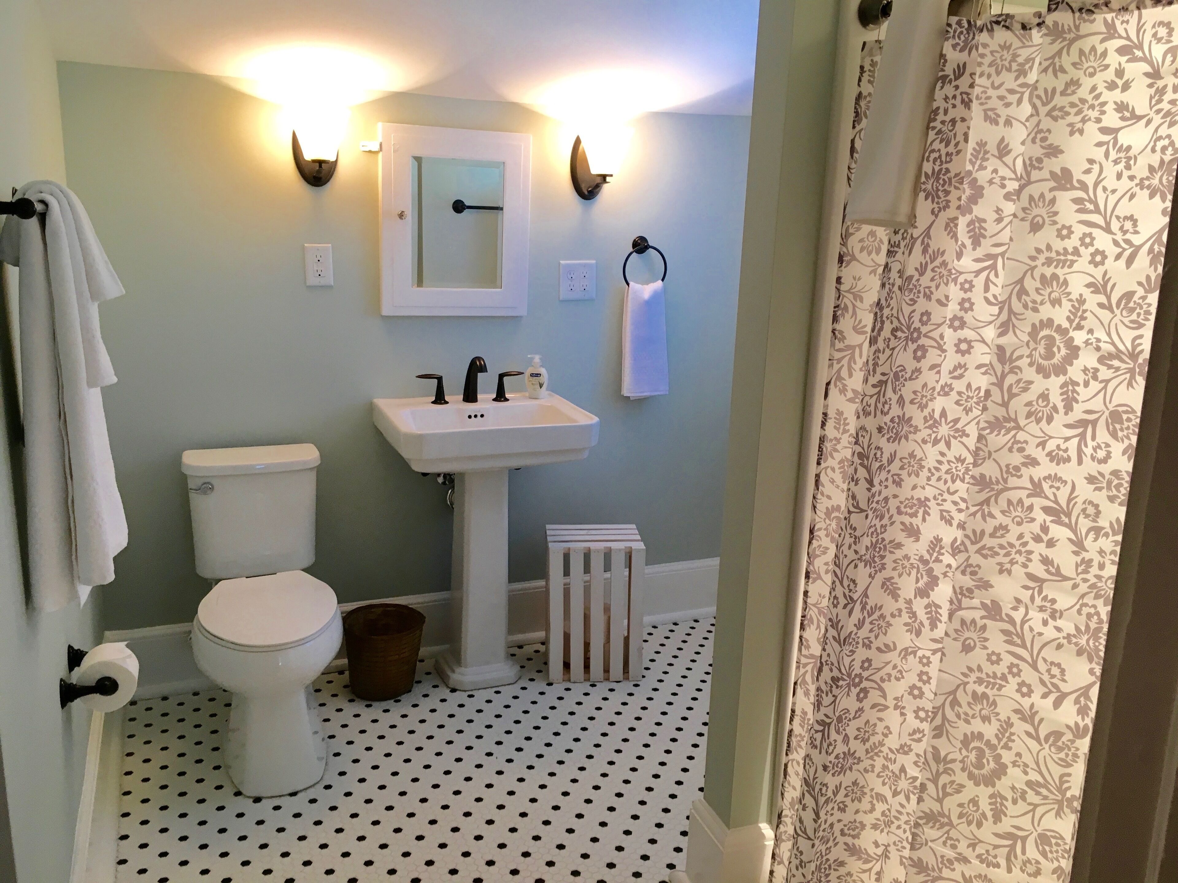 A bathroom with a toilet, sink, and a shower curtain.