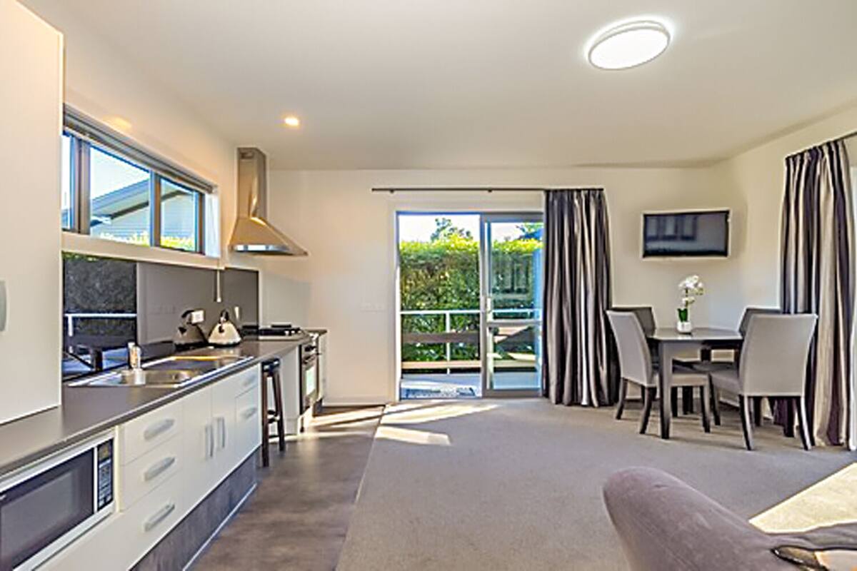 A modern kitchen with a dining area and a balcony.