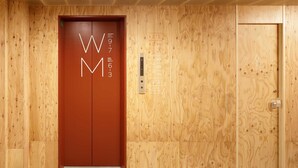 Ein Holzelevator mit Schildern, die Bereiche nur für Frauen bzw. nur für Männer kennzeichnen.