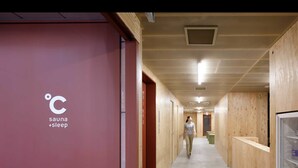 Ein Korridor mit Holzwänden und einem Schild, das eine Sauna und eine Schlafeinrichtung anzeigt.