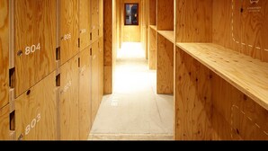 Ein Holzboden-Flur mit nummerierten Spinden und einer Sitzbank.