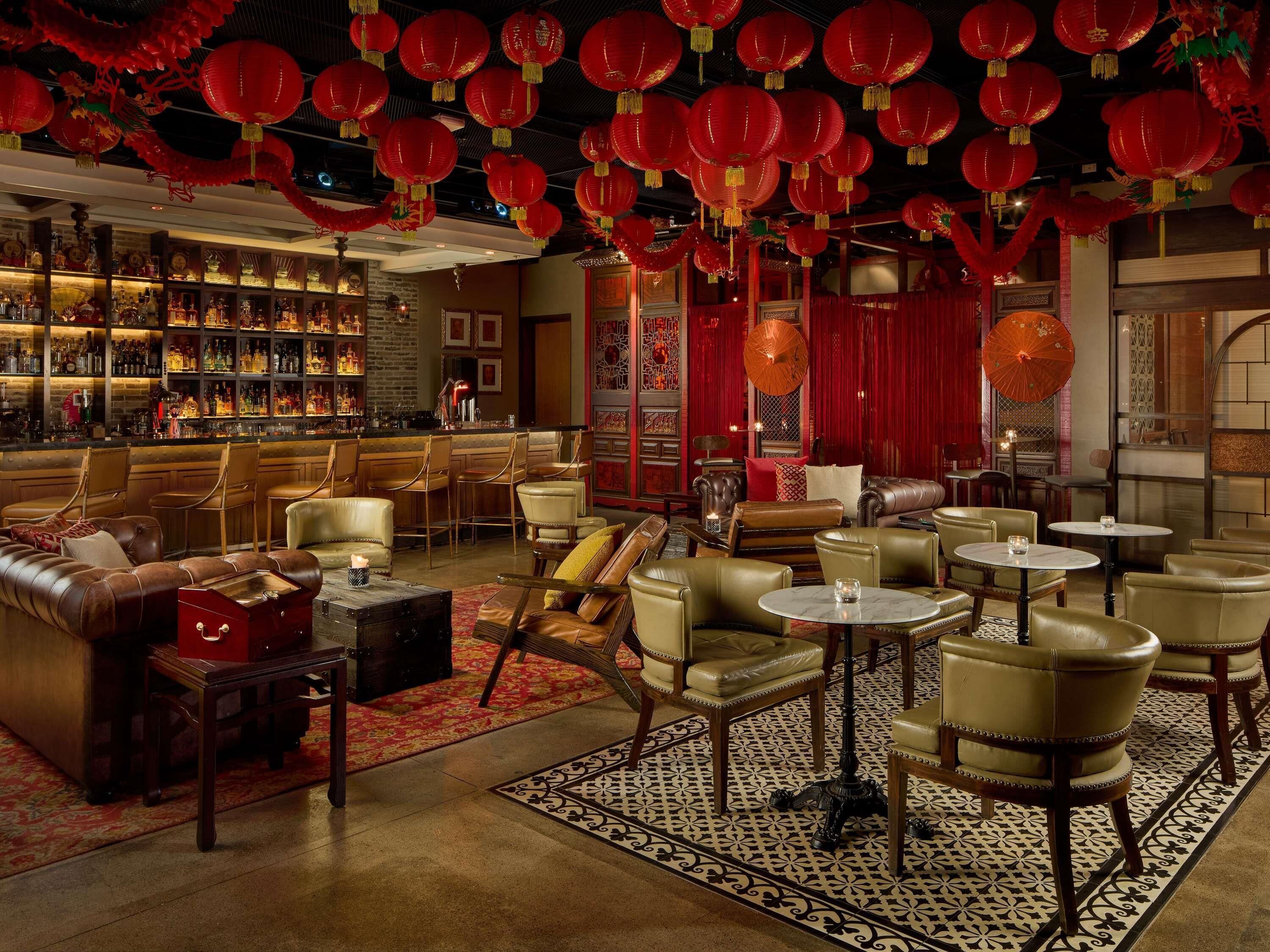 A bar area with leather seating and a variety of bottles on shelves.