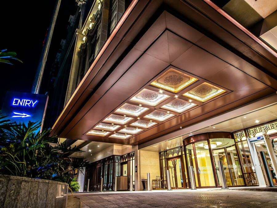 A hotel entrance with a prominent 'ENTRY' sign, a glass facade, and a modern architectural design.