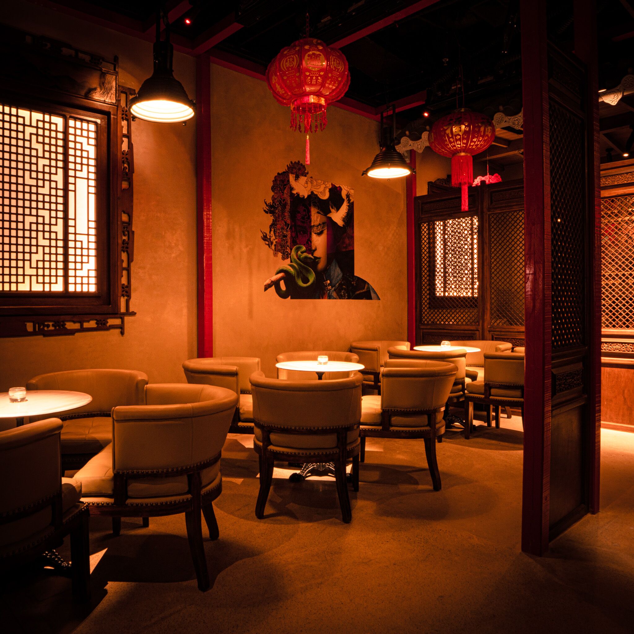 A dimly lit restaurant interior with traditional decor, including wooden furniture and red lanterns.